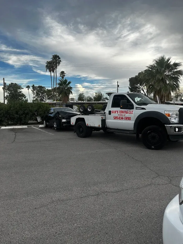 Roadside tire change being performed beside a tow truck