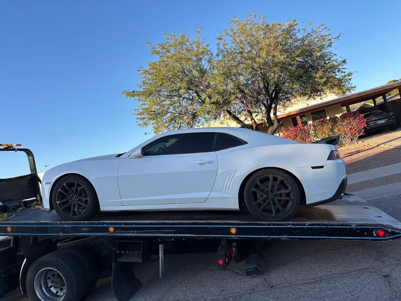 Car secured on a flatbed tow truck with four-point tie-downs